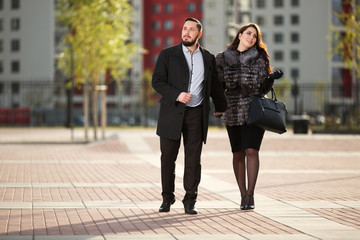 Happy young fashion couple in love walking on city street