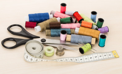 Fototapeta na wymiar sewing supplies, threads, needles, thimble, scissors