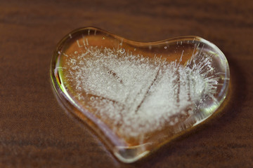 Heart of ice on brown background