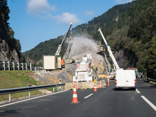 heavy engineering road construction in Spain. The removal of a large rock on the side of the road to make way for road extentions.