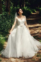 Gorgeous brunette bride posing in sunny park