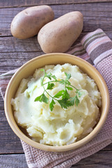 Mashed potatoes  in ceramic bowl on wooden table