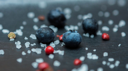 Blueberry berries with sugar granules close-up on a dark background