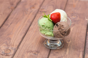 colorful ice cream with strawberries on a wooden background