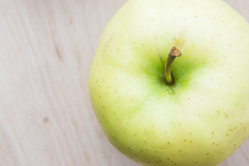 Green or yellow apple in wooden plate.