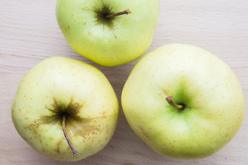 Green or yellow apples in wooden plate.