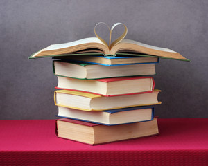 stack of books on the table, an open book on top.