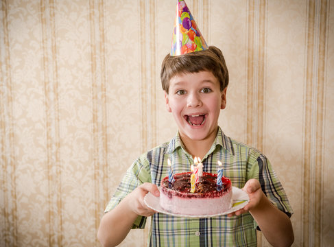 Smiling boy holding birthday cake, space for text