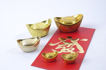 Chinese new year festival decorations, ang pow or red packet and gold ingots. Chinese characters...