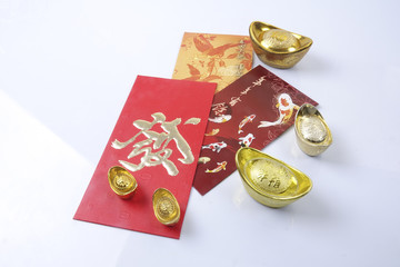 Chinese new year festival decorations, ang pow or red packet and gold ingots. Chinese characters means luck,wealth and prosperity.