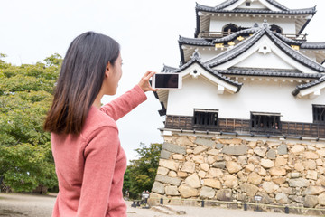 Fototapeta premium Woman taking photo on Hikone Castle