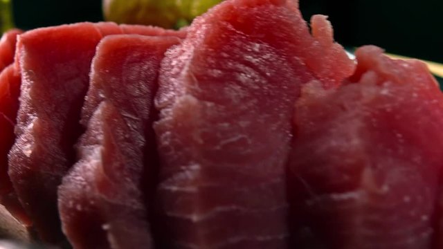 Cut tuna fillet pieces on wooden board. 4K close-up dolly video