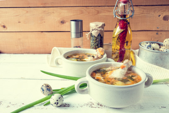 Cheese soup with chicken, herbs and vegetable. Cheese, cucumbers and herbs on wooden table. Light background.