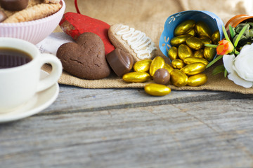 Heart shaped cookies (big and small as couple), cup of coffee, bouquet of flowers decoration. sunny morning. Romantic breakfast or Valentine's Day Breakfast. Toned image 