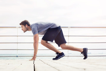 Sports man in start position outdoors