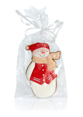 Snowman gingerbread in transparent packing with a bow.