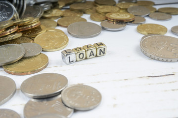 LOAN word with coins on rustic background. Business concept. Shallow DOF