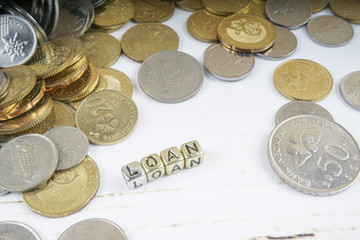 LOAN word with coins on rustic background. Business concept. Shallow DOF