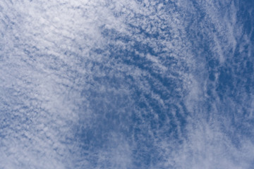 Pattern of white cirrus clouds in blue sky.