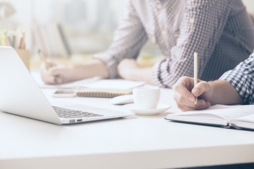 Boys writing in notepads closeup