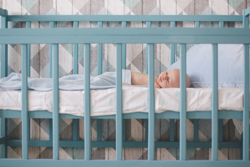 Obraz na płótnie Canvas Newborn baby sleeping in baby bed in children's room.