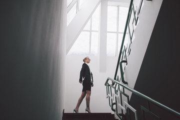 Young business woman standing on stair in the office.