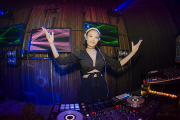 Blurred Lady Dj in club party,slow sync flash technique is feeling movement.