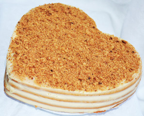 Торт в форме сердца на белой скатерти/Cake in the shape of a heart on a white tablecloth