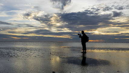 Silhouette of photographer at the beach during sunset.