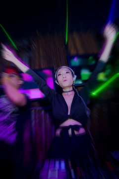 Blurred Lady Dj in club party,slow sync flash technique is feeling movement.