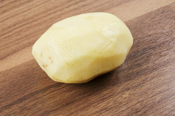 Fresh raw potato on wood table.