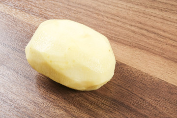 Fresh raw potato on wood table.