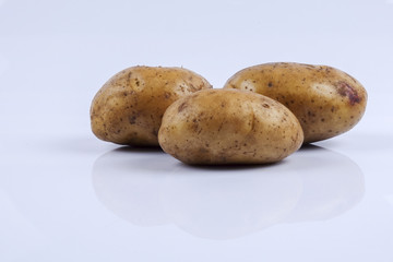 Fresh raw potato on white background.
