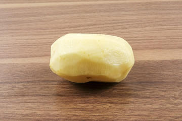 Fresh raw potato on wood table.