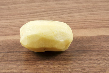 Fresh raw potato on wood table.