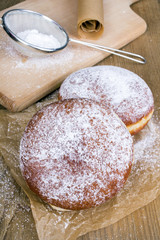 donuts with powdered sugar on a wooden table