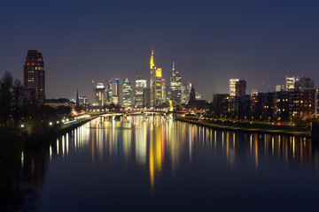 Fototapeta na wymiar Picturesque view of business district with skyscrapers and mirror reflections in the river at dark night, Frankfurt am Main, Germany