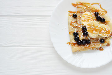 Pancakes with berries and banana on a white background