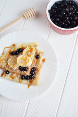 Pancakes with berries and banana on a white background