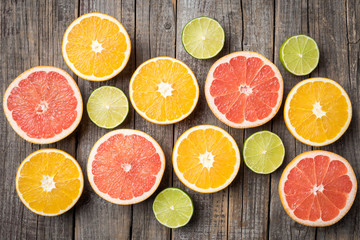 Naklejka na ściany i meble Colorful fruits background with orange, grapefruit and lime halves. Top view