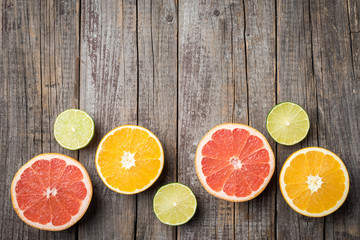 Fototapeta na wymiar Colorful fruits background with orange, grapefruit and lime halves. Top view