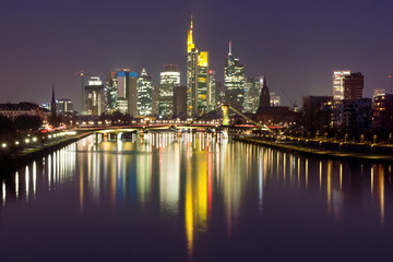 Fototapeta na wymiar Picturesque view of business district with skyscrapers and mirror reflections in the river at dark night, Frankfurt am Main, Germany