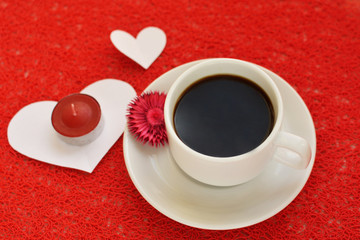 White cup and saucer with a red background