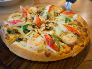 Delicious seafood pizza on wooden table