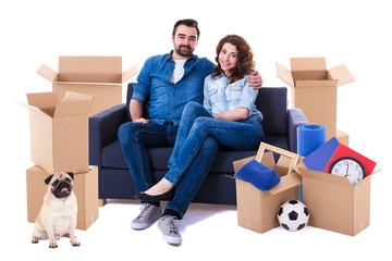 moving day and new home concept - lovely couple sitting on sofa