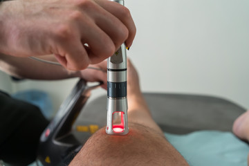Laser therapy on a knee used to treat pain