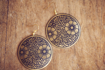 Fototapeta na wymiar Fashionable earrings on wooden background