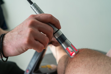 Laser therapy on a knee used to treat pain