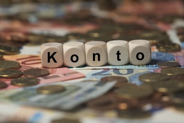 konto - Holzwürfel mit Buchstaben im Hintergrund mit Geld, Geldscheine