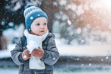 Adorable little boy having fun on winter day